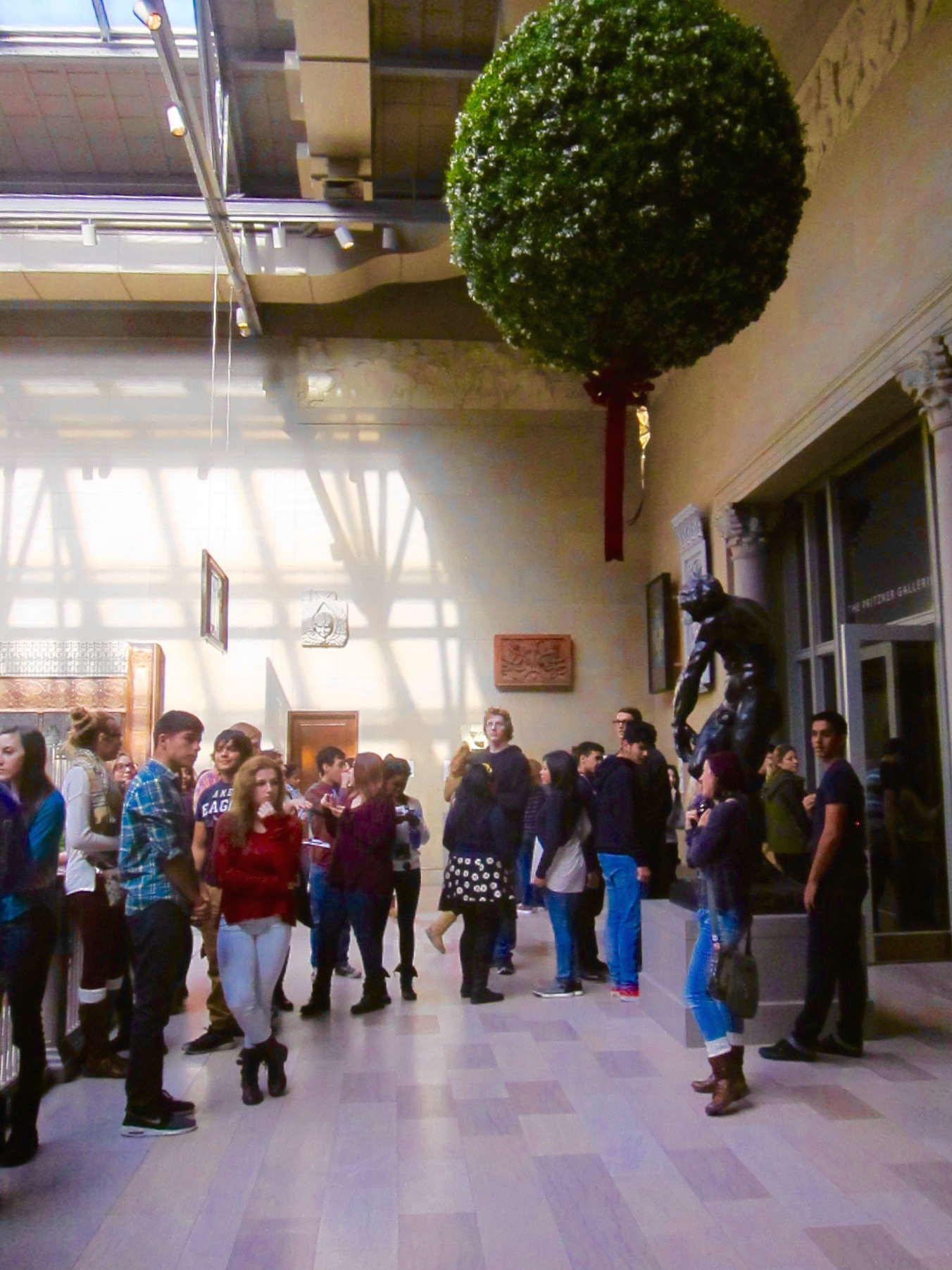 Teens studiously avoiding an enormous mistletoe at a major Chicago museum.