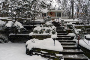 A long flight of shoveled stairs ascends toward a house.